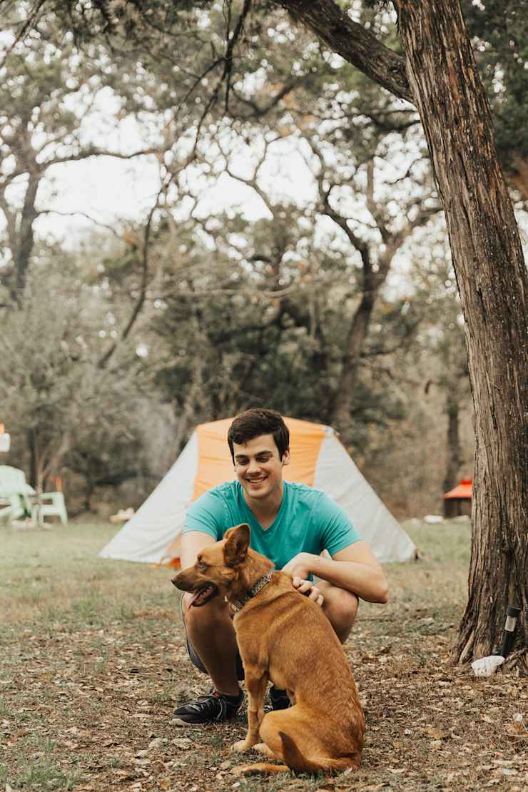 host-petting-dog-at-campsite