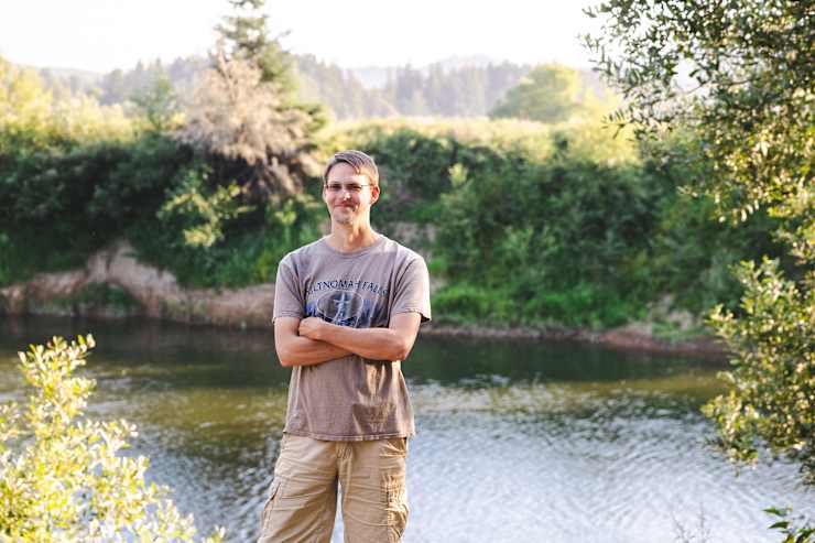 host-standing-by-river