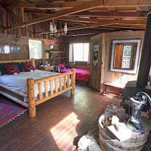 The Cowboy Room is roomy and rustic, with a private bathroom and forest views on both sides.
