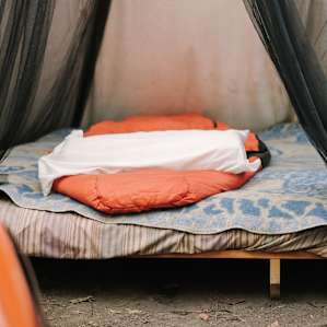 Wooden flat with mattress inside.