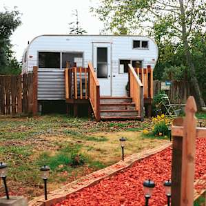 To the left of the path is a small trailer which has been revamped into an amazing little bathhouse!