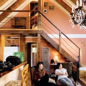 Living room with staircase up to the loft level (with a desk & twin bed)