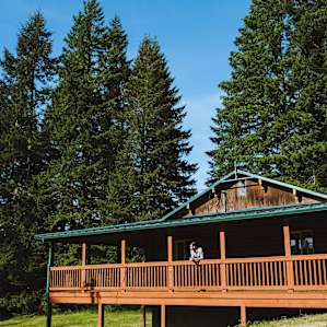 The porch around the perimeter of the cabin is perfect for relaxing and taking in the view of the surrounding forest.