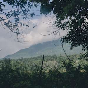Mountains beyond the campsite with ethereal clouds covering the top.