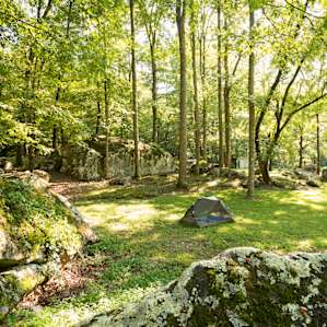 Tent site surrounded by giant, mossy boulders.