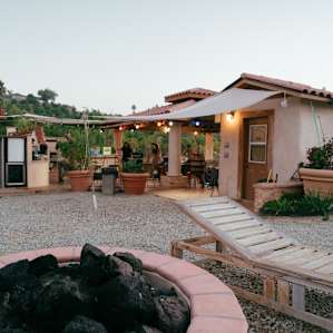 A wonderful firepit looking into the outdoor kitchen - fantastically furnished and has so many amenities for your gourmet cooking!