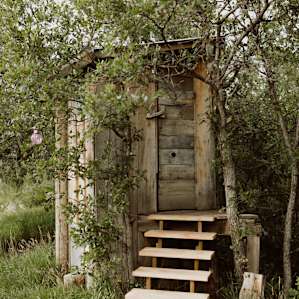 Outhouse is stocked with candles and incense, smells nice and has a pleasant view!