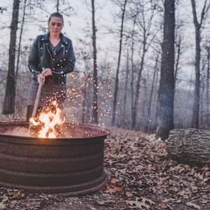 The fire pit behind the cabin, host leaves firewood nearby.