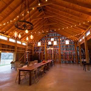 String lights and wagon-wheel chandeliers inside the barn. Very cool space!