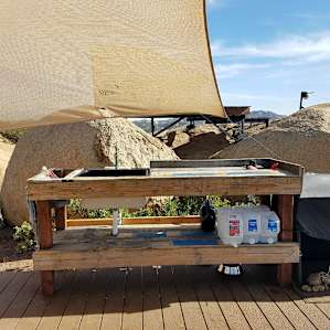 The food prep area with working sink. The stove is just to the right with a black cover on it. The platform that you see in the background is the doghouse platform.