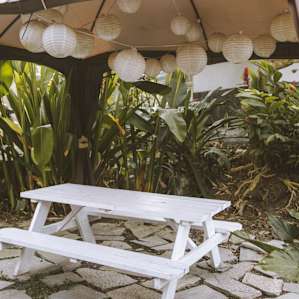 Outdoor picnic table area outside the blue cottage with hanging lanterns