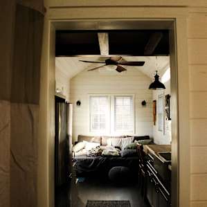 the view from the bathroom of the kitchen and couch / bed