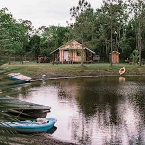 The cabin (shower and outhouse pictured too)! There's a small pond out front full of fish. Plus, kayaks/peddle boats to play with.