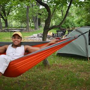 hanging out in the hammock. We set up tent beyond the trees and a little further is the pond and fire pit.