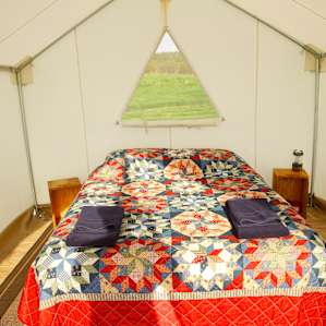 The tent is equipped with a queen sized bed, two night stands, and a heater for colder nights.