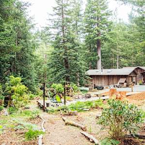 The path heading down from the campsite, to the beautiful deck with a fire pit and camping chairs.