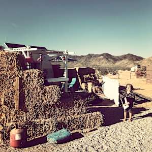 The trailer is protected from the desert winds by a stack of hay bales turning the trailer into an enclosed little wonderland