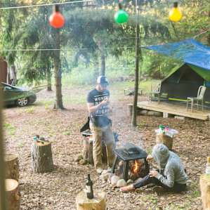 View of one of the fire pits and the tent listing from the kitchen building
