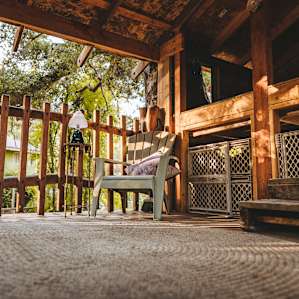 The two level tree house with reading chair on bottom level and a bed on the loft