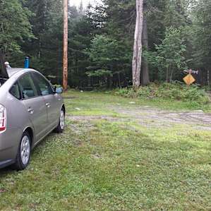 The campsite is located just next to the road at the top of the driveway.