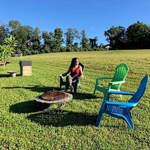Great Site setup with fire ring, chairs, a grill, and a beautifully made log bench.