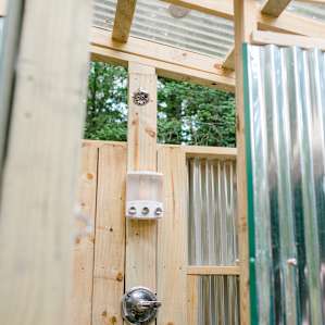 Inside the outdoor shower setup - complete with hot & cold water, soaps, bench and separate changing area.