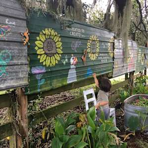 Painting on their community mural