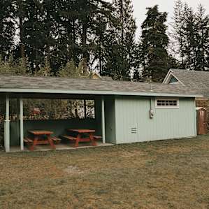 Two picnic tables beneath a shelter. There's also a porto-potty located here for use.