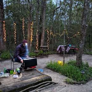 cute common area with patio tables, a fire pit, and beautiful fairy lights!