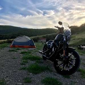 I set up my tent right along the ridge overlooking the valley, the fire pit and swing is to the right of my bike