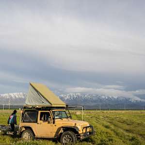 Camps are in a field with a view of mountains all around you.