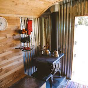 Tiny wood stove! There's firewood outside the cabin.