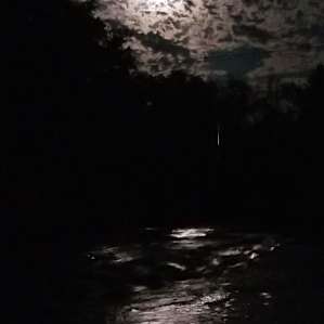 near full moon among curdled clouds, the river resplendent...