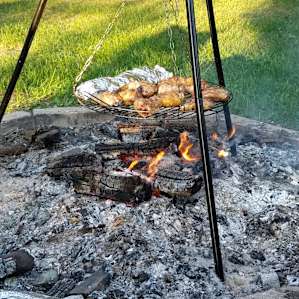 Cooking chicken thighs over the fire, bring your own tripod and enjoy cooking over the huge fire pit