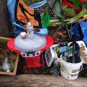 Stuff I cleaned from site. It was messy when I arrived, so I picked up trash, rafts, etc & stacked to bwtween 2 trees.