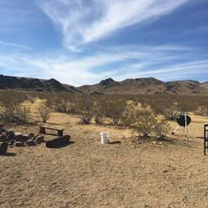 Site 3 had a fire pit with grate, a little firewood, a round table and 2 chairs, benches around the fire pit.