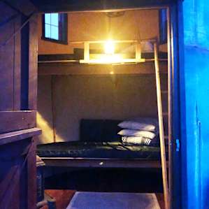 There is a lantern hanging inside the Glamp Tank near the top bunk.