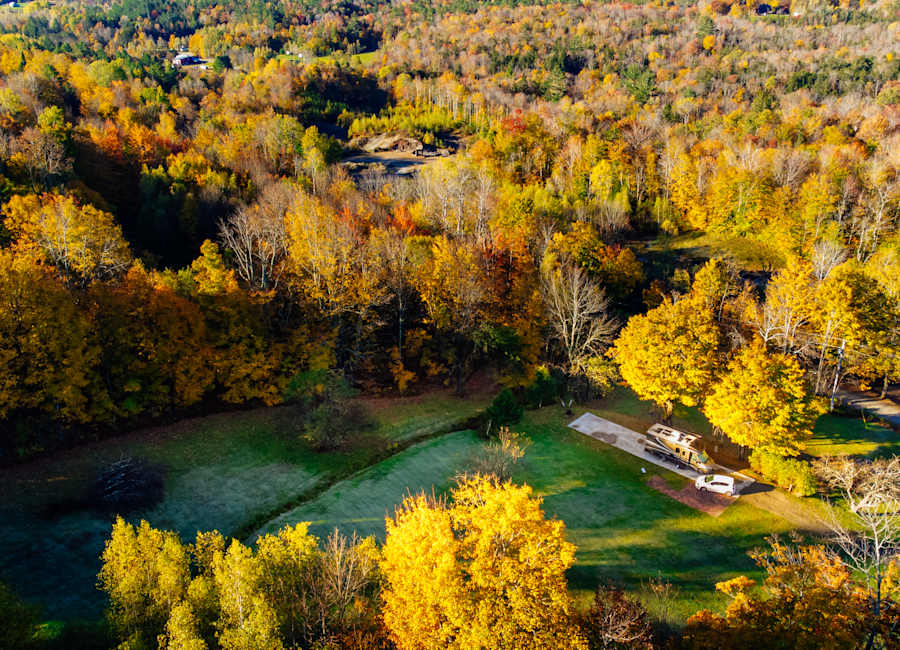 Golden autumn trees surrounding Golden Maple Farm in Vermont