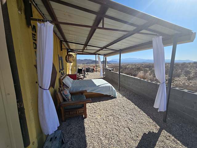White bell tent at dusk with vivid orange sunset and distant mountain range